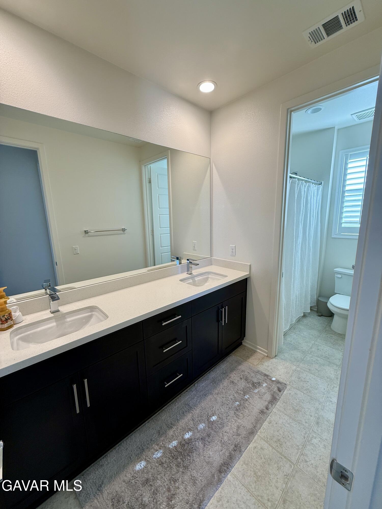 38902 Malva Rosa Drive Palmdale, CA 93551 - Photo 10 of 12 a bathroom with a double vanity sink and a mirror