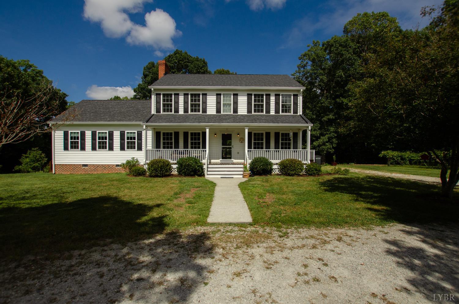 a front view of a house with garden and trees