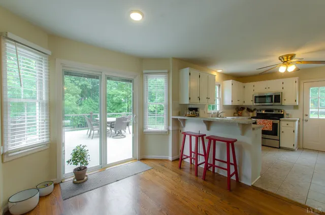 a living room with furniture kitchen view and a window