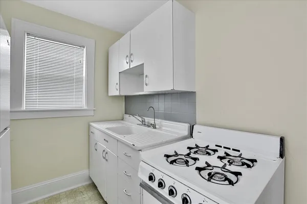 a kitchen with white cabinets and white appliances