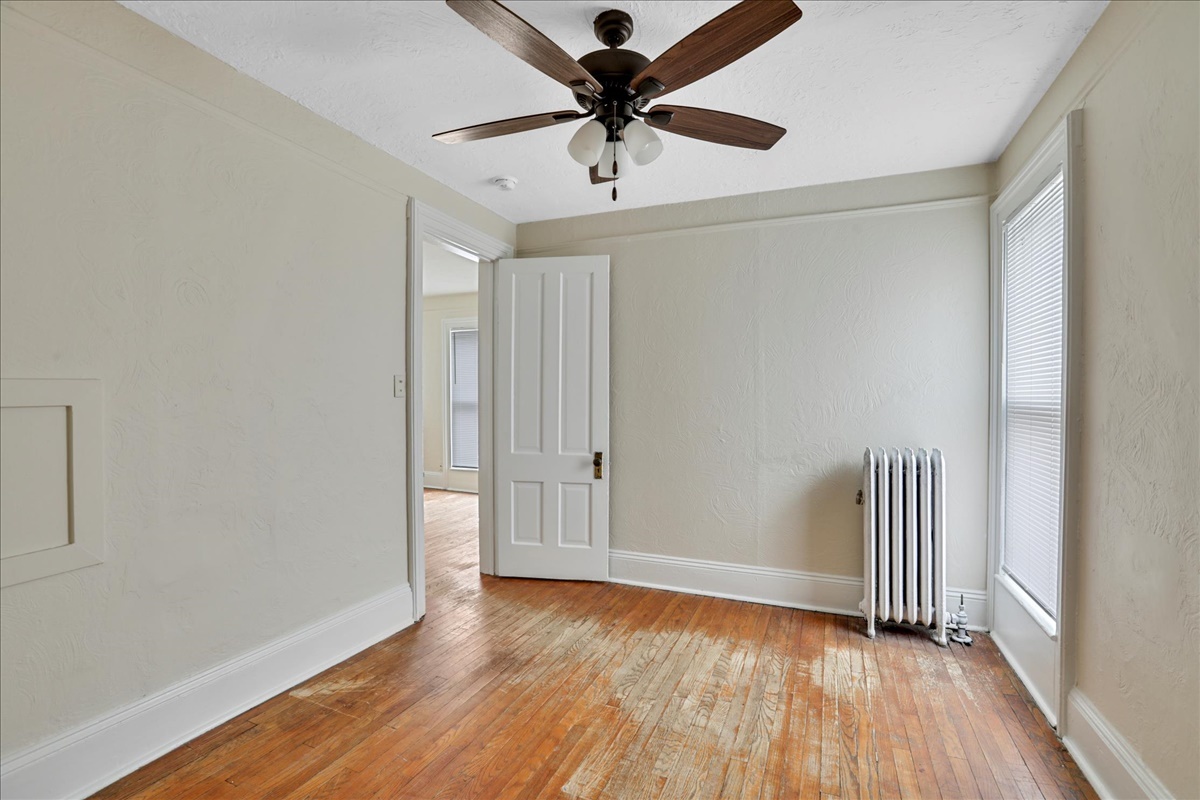 212 West High Street Urbana, IL 61801 - Photo 22 of 36 a view of room with wooden floor and a ceiling fan