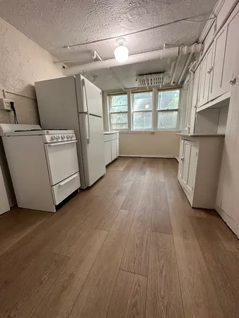 a view of a room with wooden floors and white walls