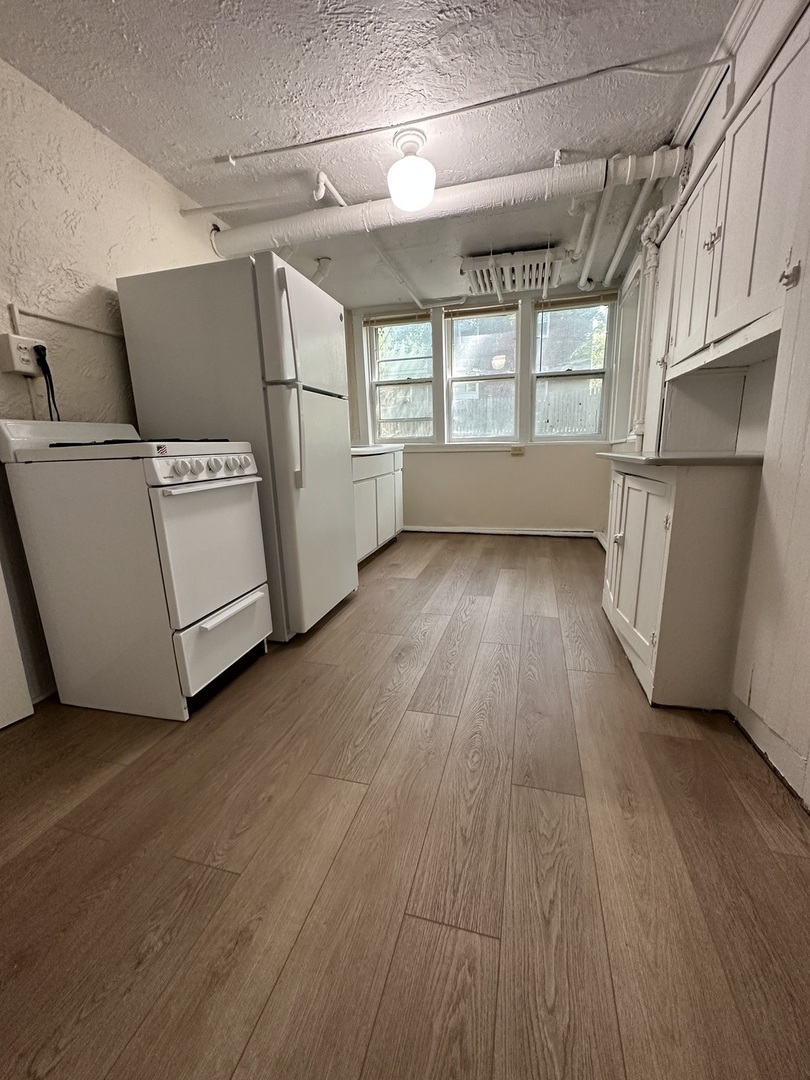 212 West High Street Urbana, IL 61801 - Photo 29 of 36 a view of a room with wooden floors and white walls