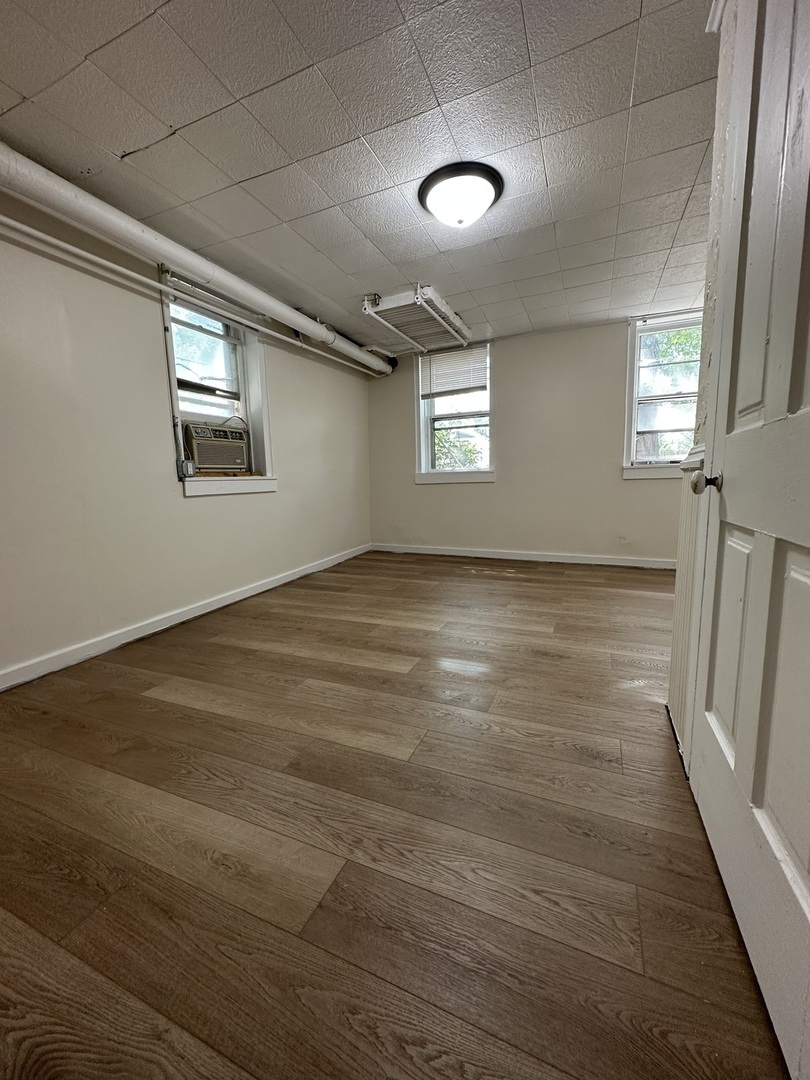 212 West High Street Urbana, IL 61801 - Photo 32 of 36 an empty room with wooden floor and windows