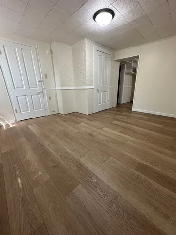 an empty room with wooden floor and white walls