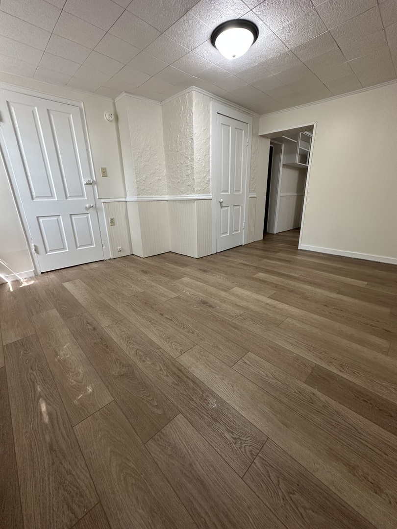 212 West High Street Urbana, IL 61801 - Photo 33 of 36 an empty room with wooden floor and white walls
