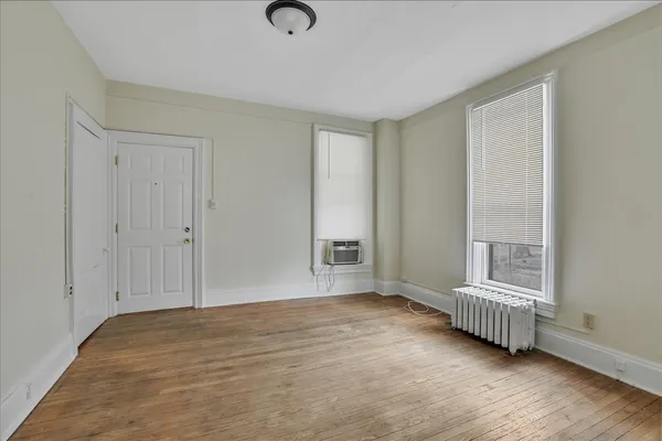 a view of a room with wooden floor and a window