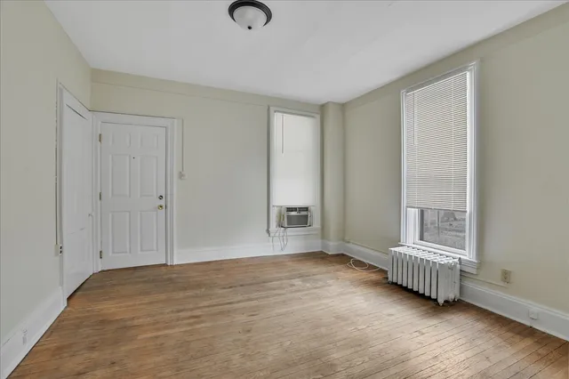 a view of a room with wooden floor and a window