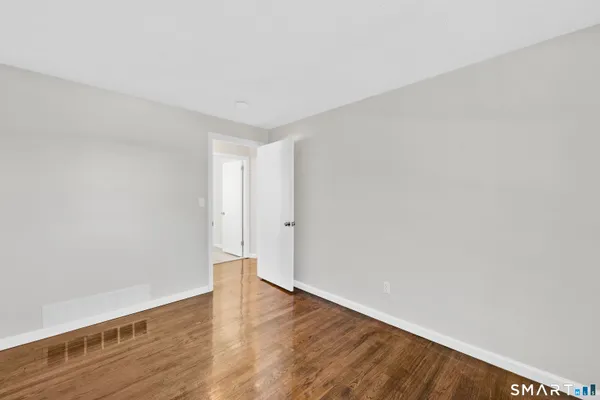 a view of an empty room with wooden floor