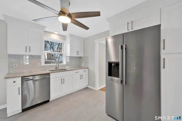 a kitchen with granite countertop a refrigerator and a sink