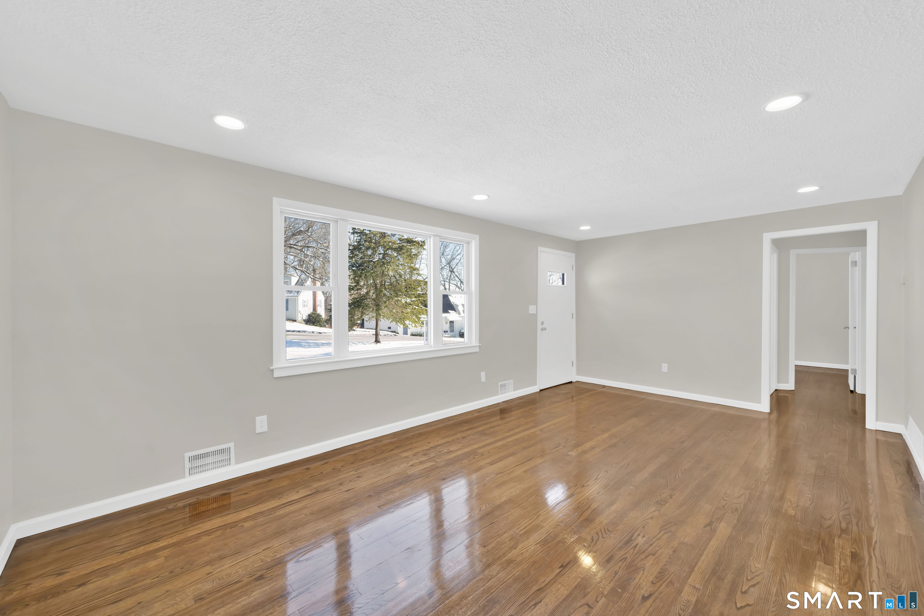 23 Bancroft Road Vernon, CT 06066 - Photo 9 of 20 a view of an empty room with wooden floor and a window