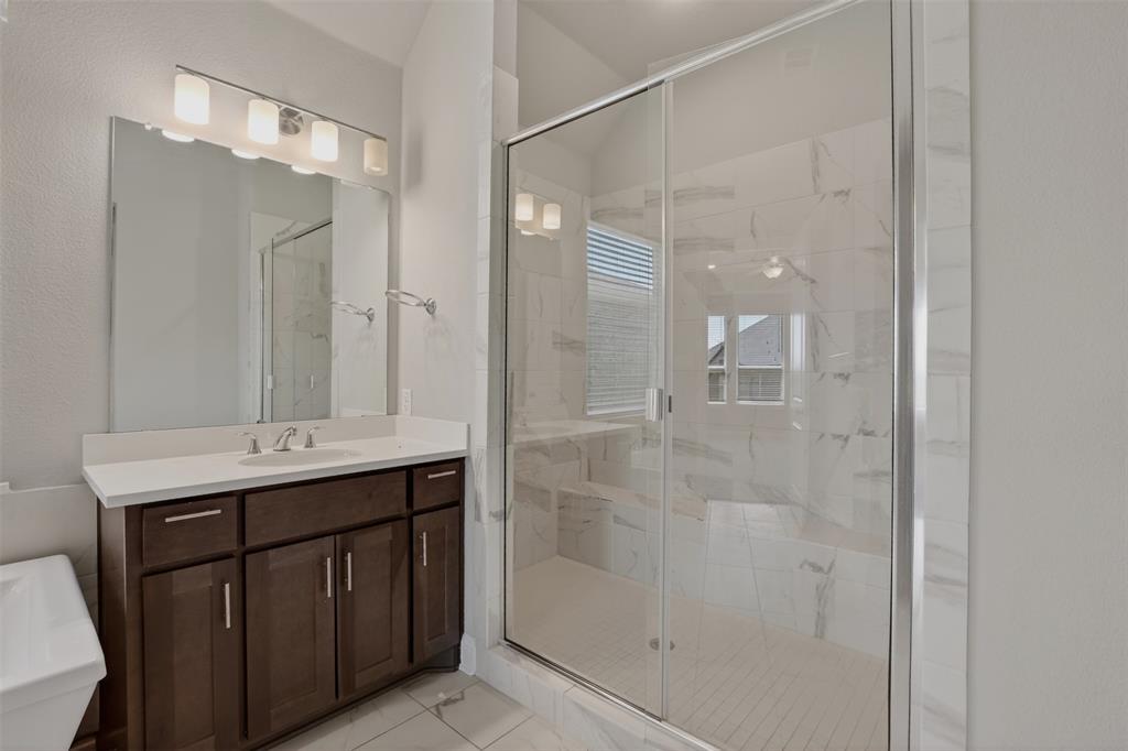 16812 Bitterroot Road Justin, TX 76247 - Photo 22 of 27 a bathroom with a shower sink and mirror