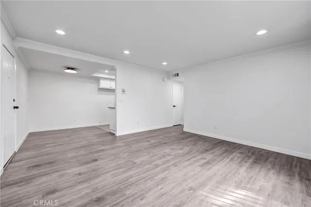 a view of an empty room with wooden floor