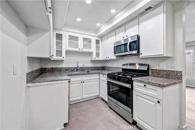 a kitchen with stainless steel appliances granite countertop a stove sink microwave and cabinets