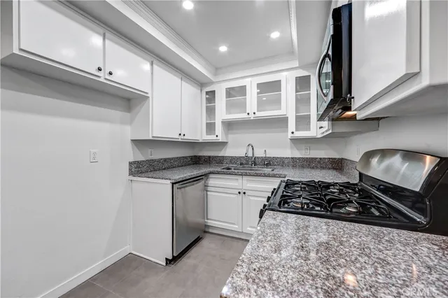 a kitchen with stainless steel appliances granite countertop a stove a sink and a microwave