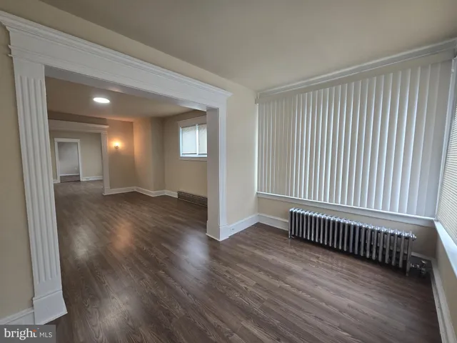 a view of a room with wooden floor and windows