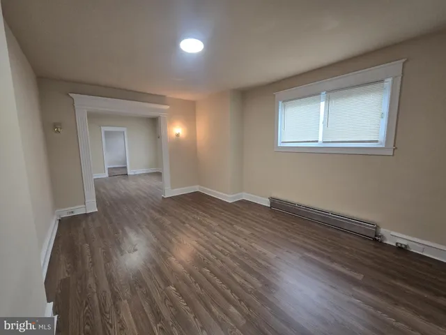 a view of a room with wooden floor and a window