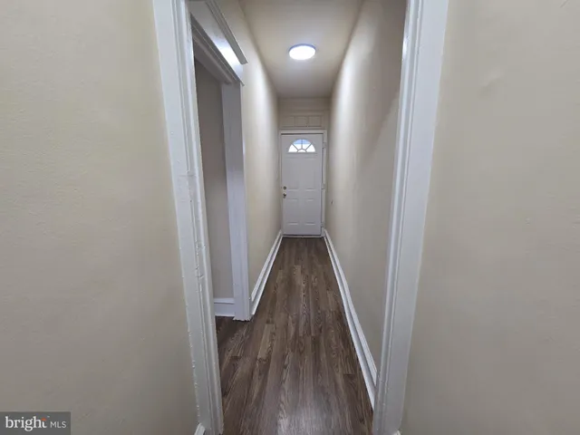 a view of a hallway with wooden floor