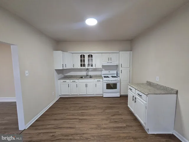 a kitchen with stainless steel appliances granite countertop a stove and white cabinets