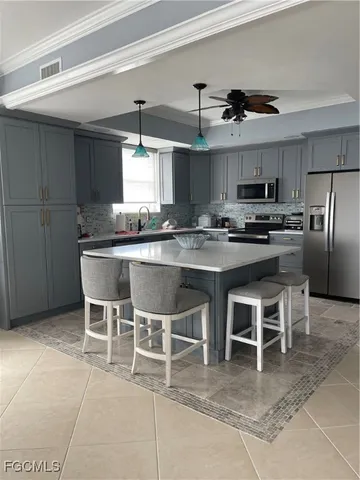 a kitchen with stainless steel appliances granite countertop a table chairs sink and cabinets