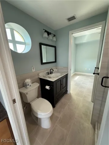 a bathroom with a toilet a sink and a mirror