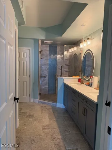 a bathroom with a double vanity sink mirror and shower