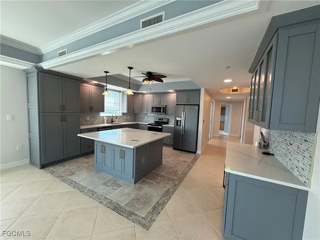 a large kitchen with kitchen island a sink stainless steel appliances and a counter top space