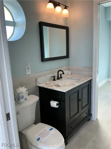 a bathroom with a granite countertop toilet sink and mirror