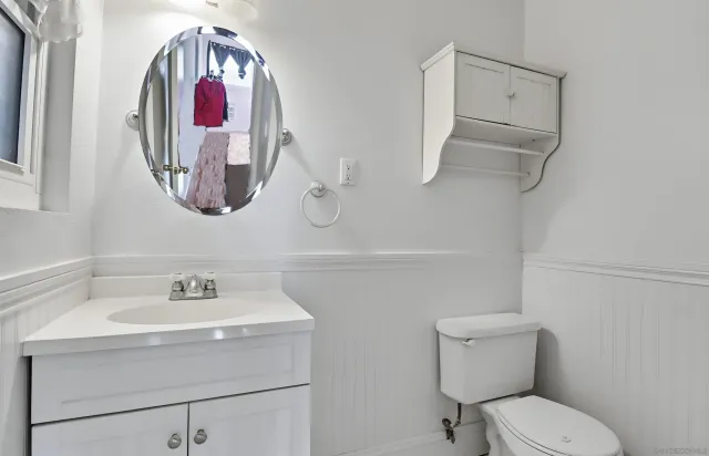 a bathroom with a toilet a sink and mirror