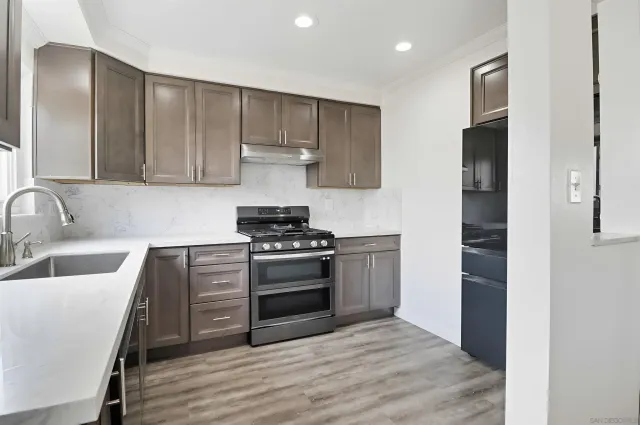 a kitchen with wooden cabinets and a stove top oven