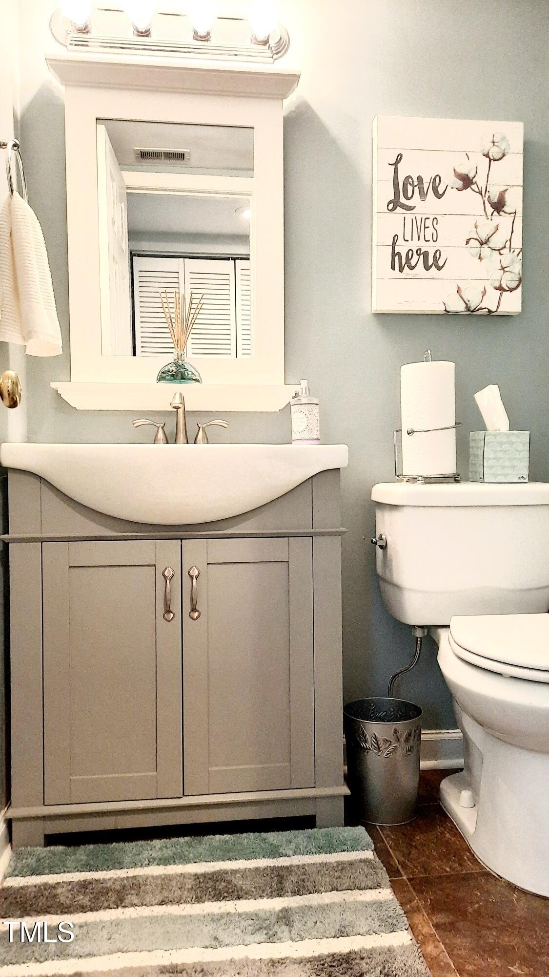 7704 Falcon Rest Circle Raleigh, NC 27615 - Photo 4 of 23 a bathroom with a granite countertop toilet sink and mirror