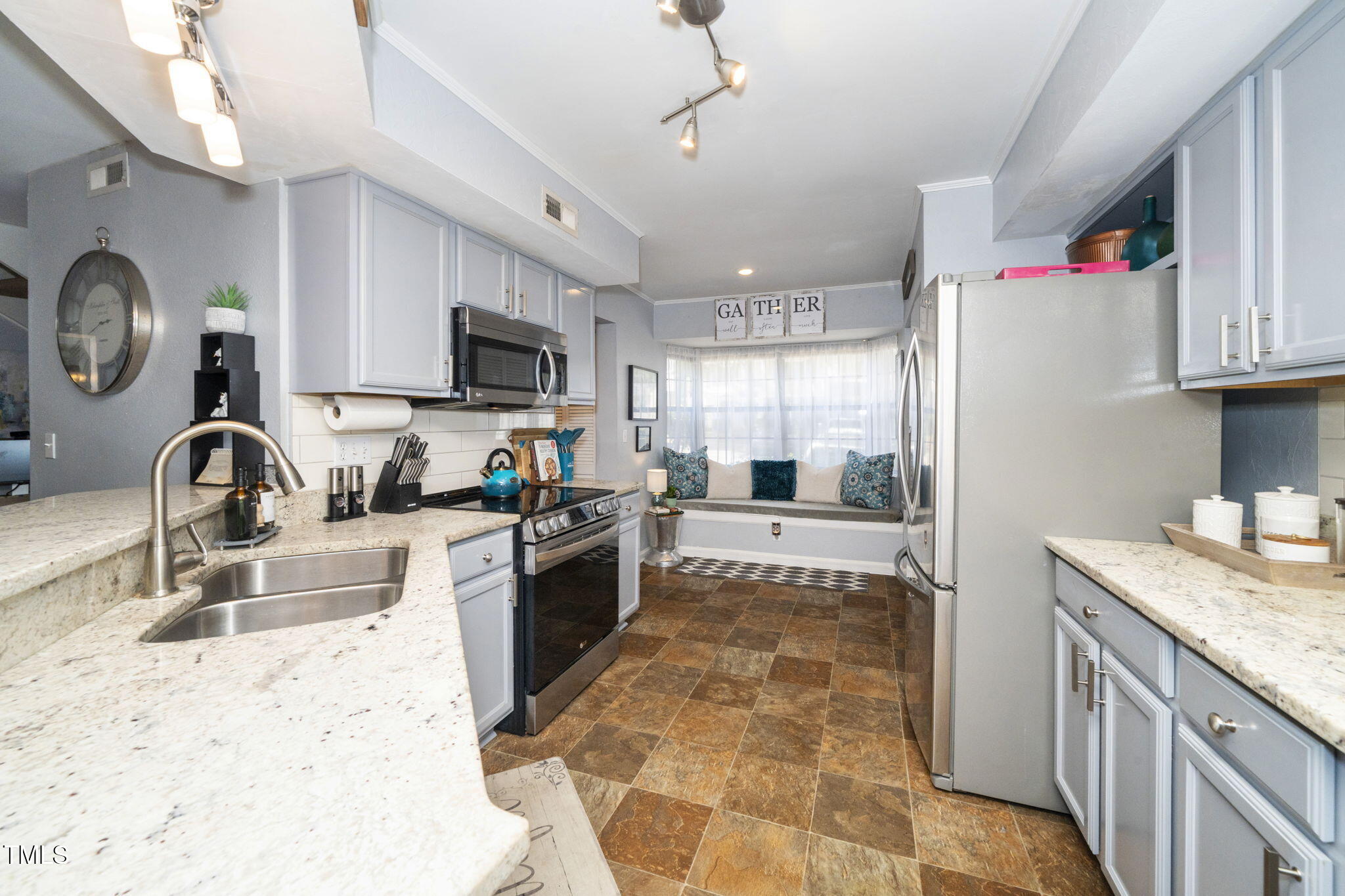 7704 Falcon Rest Circle Raleigh, NC 27615 - Photo 10 of 23 a large kitchen with kitchen island granite countertop a sink stainless steel appliances and cabinets