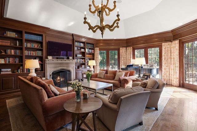 a living room with furniture a fireplace and a large window