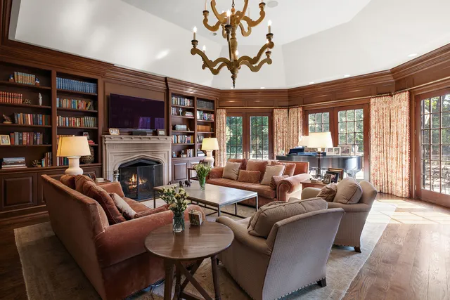 a living room with furniture a fireplace and a large window