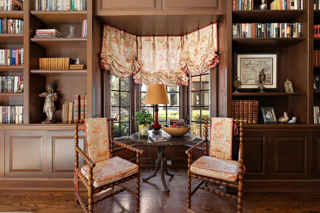 a living room with fireplace furniture and a book shelf