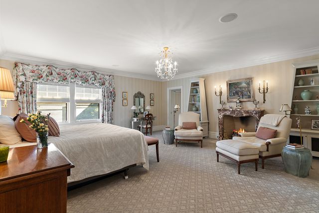 a bedroom with a bed and large windows