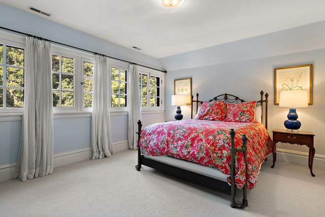 a large bed sitting in a bedroom next to a window