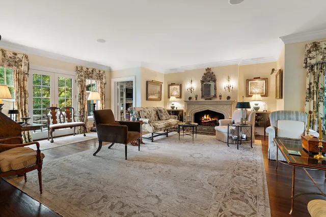 a living room with furniture a fireplace and a large window