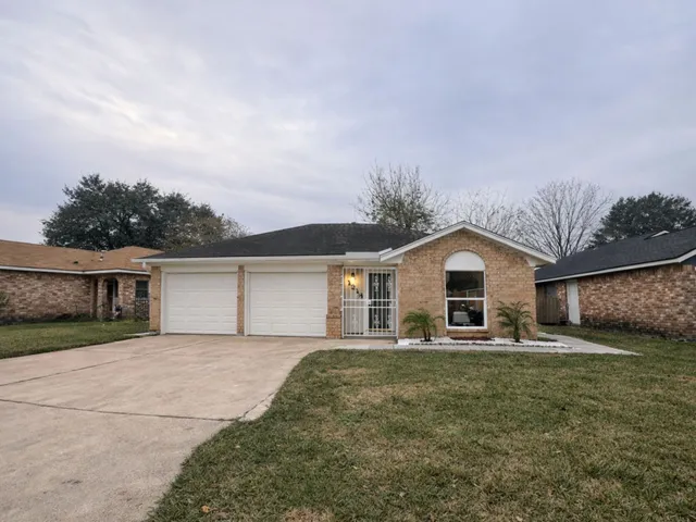 a front view of house with yard and trees in the background
