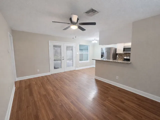 a view of a kitchen with wooden floor and a ceiling fan