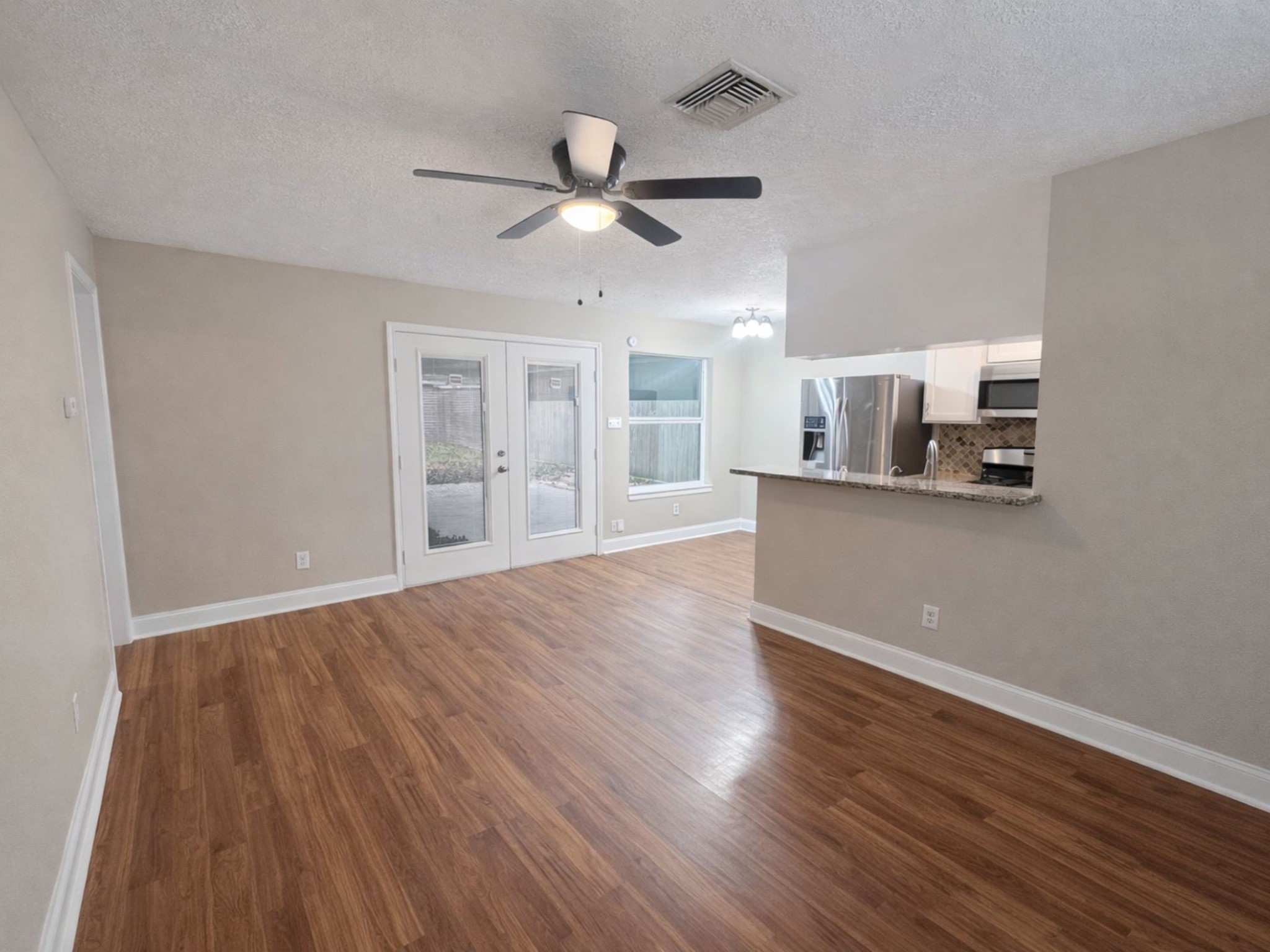 1318 Epsilon Street Pasadena, TX 77504 - Photo 5 of 15 a view of a kitchen with wooden floor and a ceiling fan