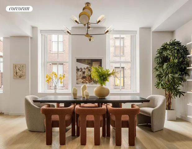 a dining room with furniture potted plants and wooden floor