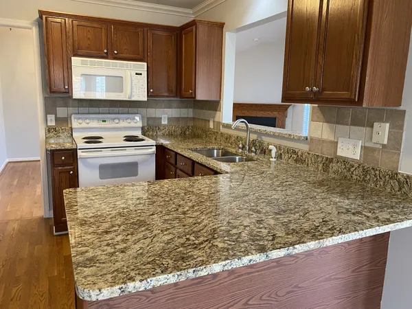 a kitchen with granite countertop wooden cabinets and a stove top oven