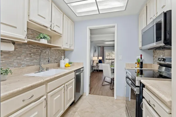 a kitchen with stainless steel appliances granite countertop a sink stove and refrigerator