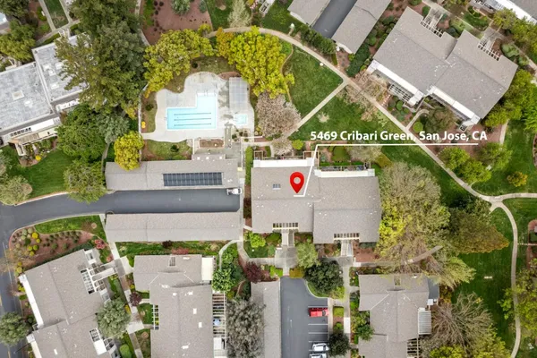 an aerial view of residential houses with outdoor space and trees