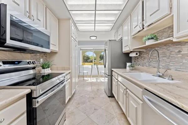a large kitchen with stainless steel appliances granite countertop a sink and stove