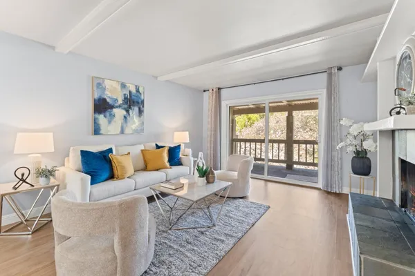 a living room with furniture large window and wooden floor