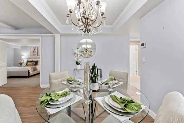 a view of a dining room with furniture a livingroom and chandelier