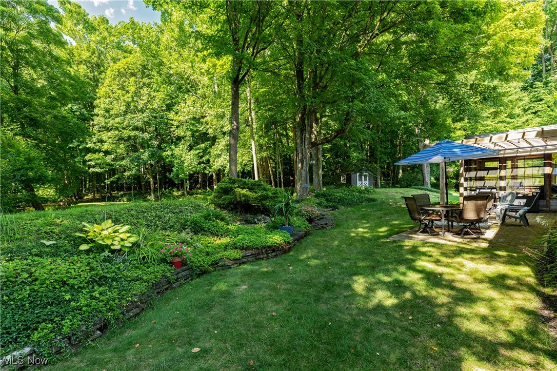 8062 Chagrin Road Chagrin Falls, OH 44023 - Photo 38 of 50 The backyard is the perfect blend of sunlit open space, mature trees, and beautifully tended gardens featuring a tranquil water element.