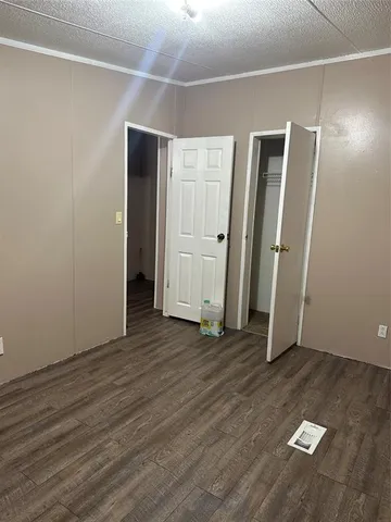 an empty room with wooden floor and closet